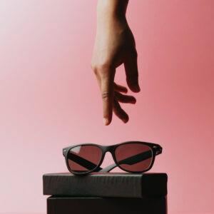 a-hand-reaches-for-black-sunglasses-sitting-on-a-case Γυαλιά Ηλίου Μαύρο 011