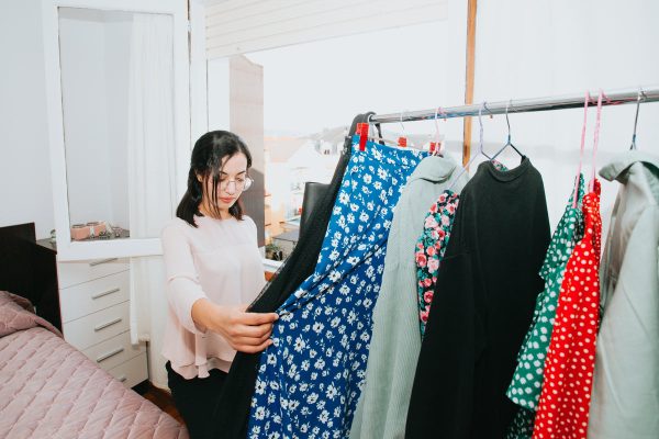 a-woman-holding-a-dress-browses-her-bedroom-clothing-rack Φόρεμα 053