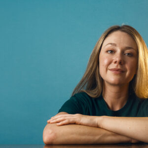a-woman-in-a-plain-green-shirt-against-a-blue-backdrop Πουκάμισο Πράσινο 006