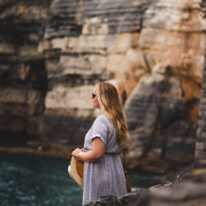 a-woman-in-a-summer-hat-stands-on-a-cliff Καπέλο Καλοκαιρινό