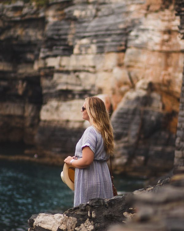 a-woman-in-a-summer-hat-stands-on-a-cliff Καπέλο Καλοκαιρινό
