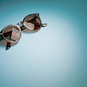 black-round-sunglasses-on-top-left-of-blue-background Γυαλιά Ηλίου Μαύρο 016