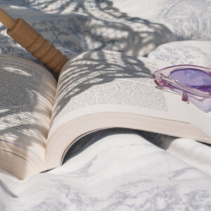 book-lays-open-next-to-purple-cateye-sunglasses Γυαλιά Ηλίου Μωβ 002