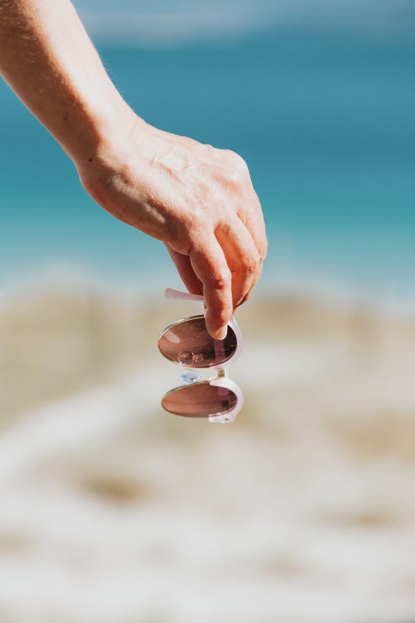 hand-hold-pink-framed-sunglasses-by-the-beach Γυαλιά Ηλίου Ροζ 009