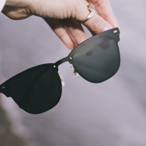 hand-holds-a-pair-of-black-sunglasses Γυαλιά Ηλίου Μαύρο