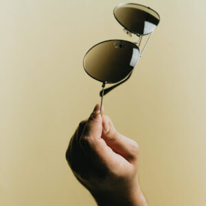 holding-sunglasses-by-the-arm-on-yellow-background Γυαλιά Ηλίου Κίτρινο 002