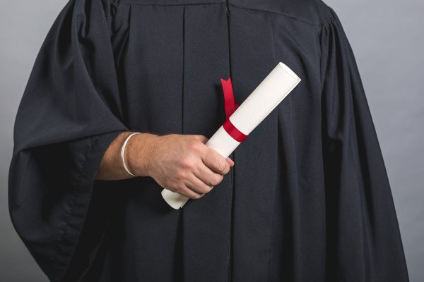 male-student-in-gown-holding-diploma Μακρύ Φόρεμα
