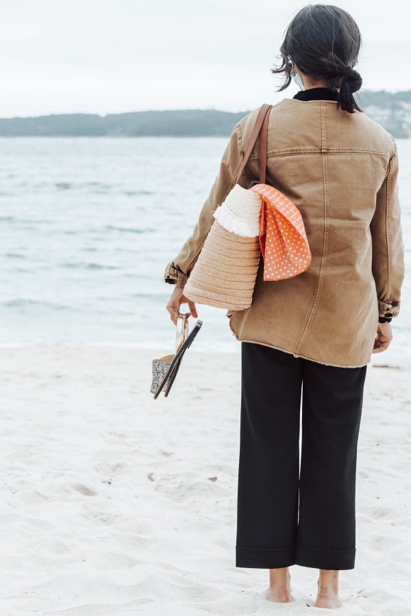 person-faces-the-water-and-holds-their-shoes-in-hand Παπούτσια 003
