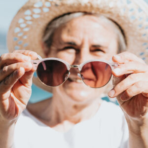 person-holds-sunglasses-out-in-front-of-them Γυαλιά Ηλίου 053