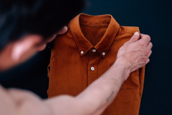 person-holds-up-an-orange-dress-shirt Φόρεμα Πορτοκαλί