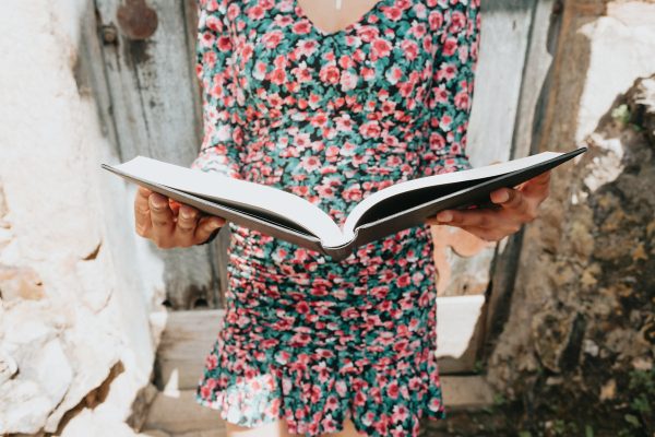 person-in-a-floral-dress-holds-a-large-book-open Φόρεμα Φλοράλ 010