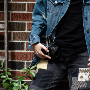 person-in-blue-jean-jacket-holds-camera-against-red-brick-wall Μπουφάν 002