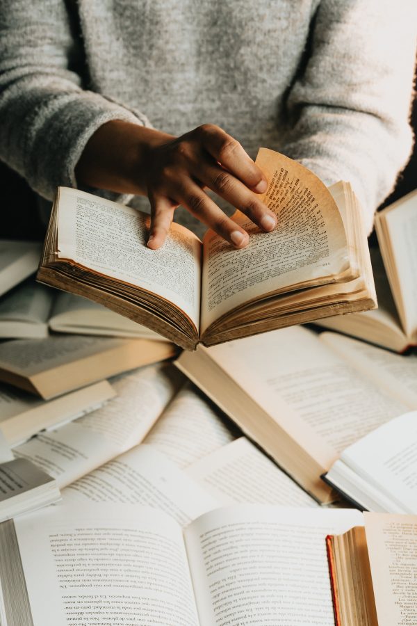 person-in-grey-sweater-holds-a-book-open-turning-the-page Πουλόβερ Γκρι 009