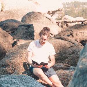 person-sits-on-rocks-and-reads-a-novel-in-white-shirt Πουκάμισο Λευκό 033