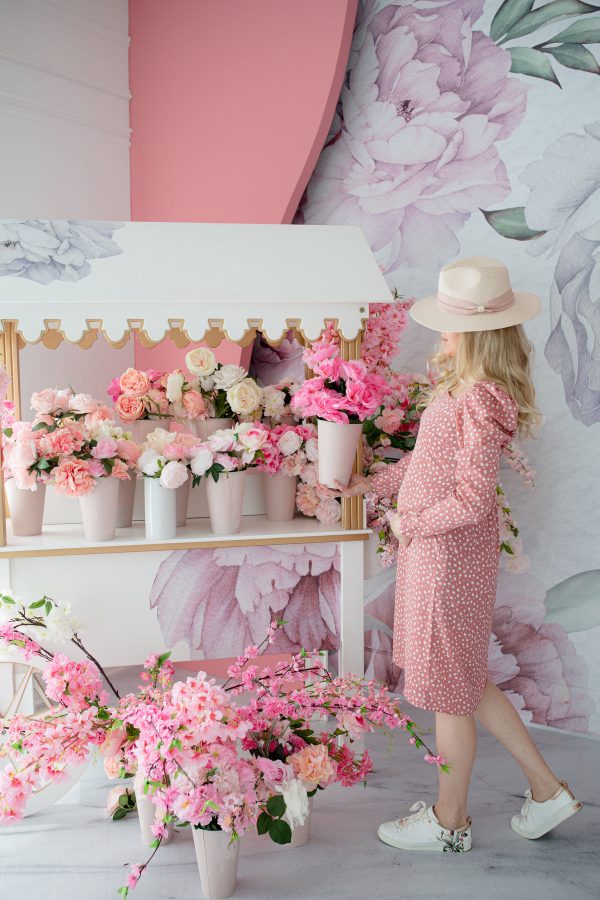person-stands-by-pink-flower-stand-in-polka-dot-dress Φόρεμα Ροζ 003
