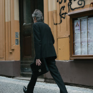 person-walks-quickly-with-bags-by-a-brown-building Τσάντες Καφέ
