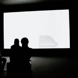 three-woman-watch-a-glowing-white-screen-in-a-dark-room Ρολόι Λευκό 002