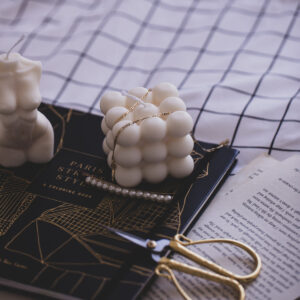 unlit-candle-on-book-with-a-draped-gold-necklace Κολιέ Χρυσό 010