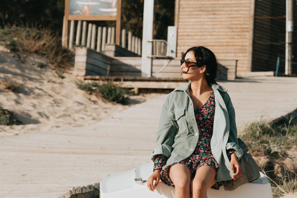 woman-in-floral-dress-sits-by-a-wooden-boardwalk Φόρεμα Φλοράλ 008