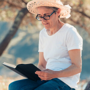 woman-in-straw-hat-on-a-wooden-log-reading-a-book Καπέλο 025