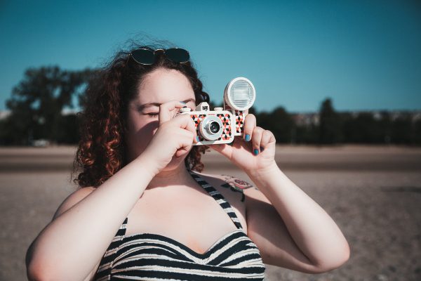young-woman-in-sunglasses-taking-photograph-on-beach Γυαλιά Ηλίου 026